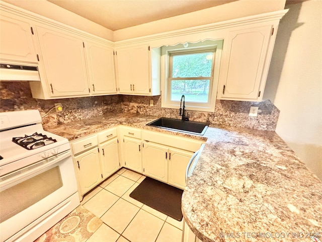 106 E Elk Rd, Whitefield, OK 74472 - kitchen with gas range gas stove, under cabinet range hood, decorative backsplash, light tile patterned floors, and light countertops