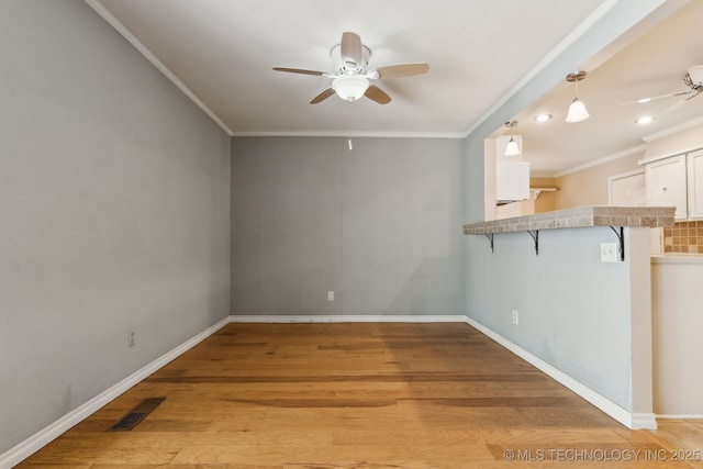 8202 S Ash Pl, Broken Arrow, OK 74011 - spare room featuring a ceiling fan, ornamental molding, and light wood-style flooring
