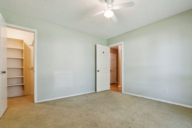 8202 S Ash Pl, Broken Arrow, OK 74011 - unfurnished bedroom featuring carpet floors, a walk in closet, a textured ceiling, a ceiling fan, and a closet