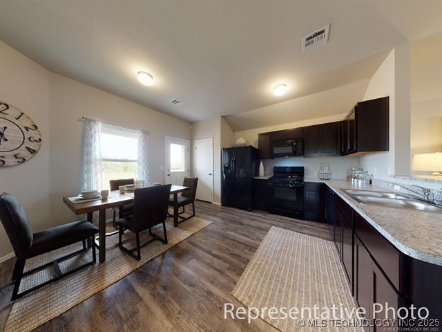 28416 E 118th Pl S, Coweta, OK 74429 - kitchen featuring black appliances, light countertops, dark wood finished floors, dark brown cabinets, and vaulted ceiling