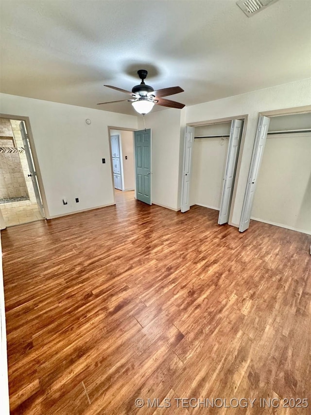5101 S Spruce Dr, Sand Springs, OK 74063 - unfurnished bedroom with light wood-style floors, multiple closets, and a ceiling fan