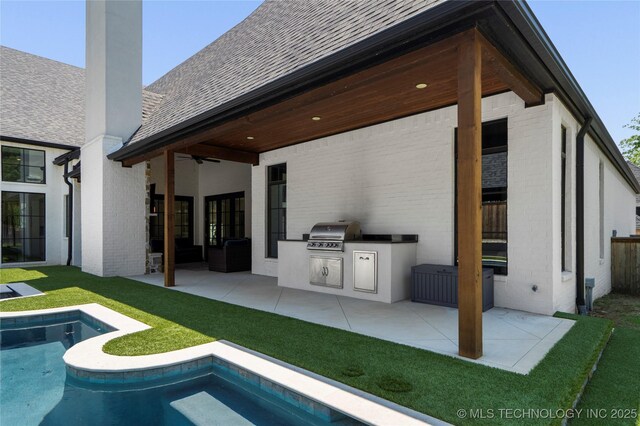 3207 E 44th St, Tulsa, OK 74105 - back of property with an outdoor kitchen, ceiling fan, an outdoor pool, and brick siding