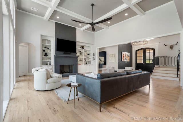 3207 E 44th St, Tulsa, OK 74105 - living area featuring arched walkways, a high ceiling, ceiling fan, beam ceiling, and a fireplace