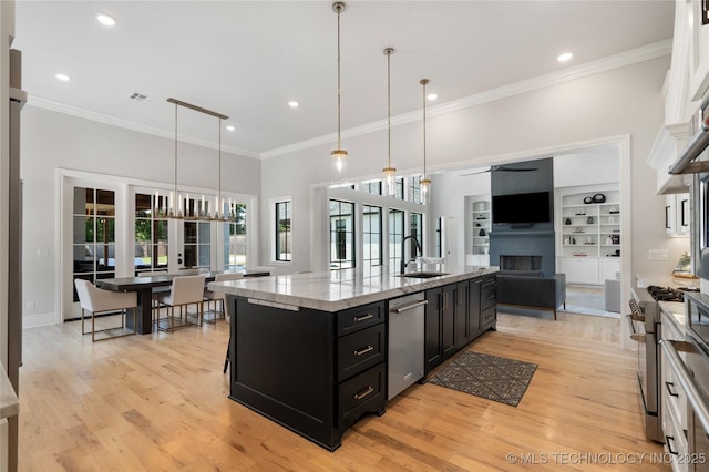 3207 E 44th St, Tulsa, OK 74105 - kitchen with dark cabinetry, stainless steel appliances, a fireplace, ceiling fan, and a large island