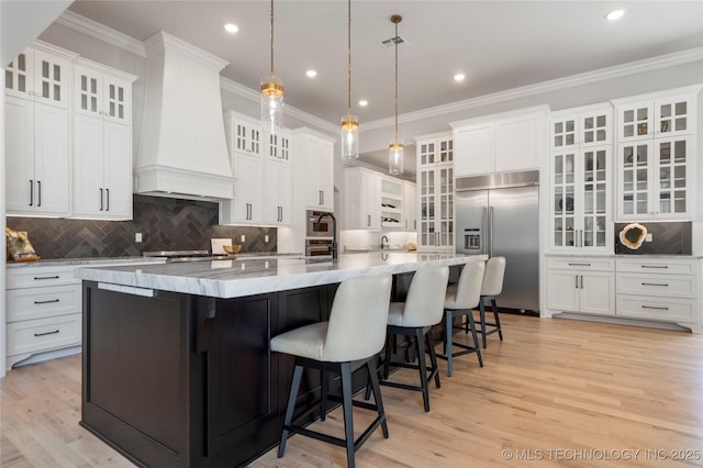 3207 E 44th St, Tulsa, OK 74105 - kitchen featuring built in refrigerator, backsplash, premium range hood, white cabinets, and a large island
