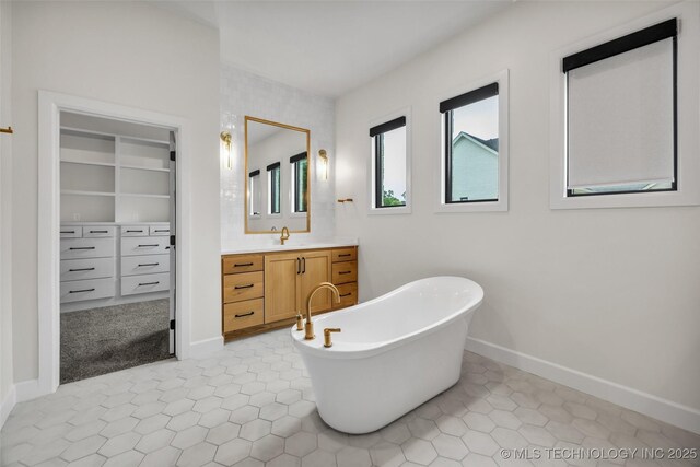 6364 N Blue Sage Dr, Owasso, OK 74055 - bathroom featuring vanity, a freestanding tub, a walk in closet, and tile patterned floors