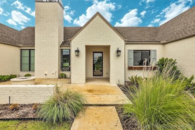 6364 N Blue Sage Dr, Owasso, OK 74055 - entrance to property with a chimney, a shingled roof, brick siding, and a patio area