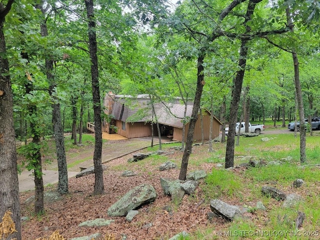 1296 Robin Hood Rd, Eufaula, OK 74432 - view of front of property featuring a chimney, a forest view, a shingled roof, and an outdoor structure