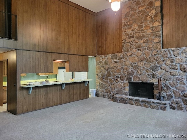 1296 Robin Hood Rd, Eufaula, OK 74432 - kitchen featuring freestanding refrigerator, carpet flooring, a breakfast bar area, a fireplace, and a high ceiling