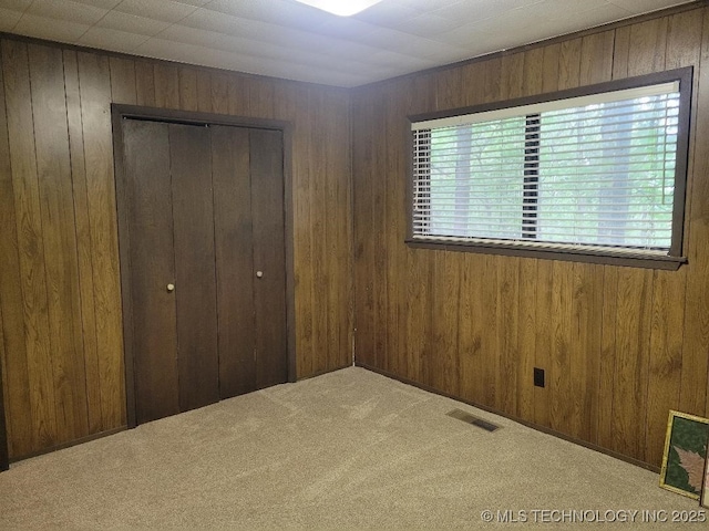 1296 Robin Hood Rd, Eufaula, OK 74432 - unfurnished bedroom with a closet, wooden walls, and carpet flooring