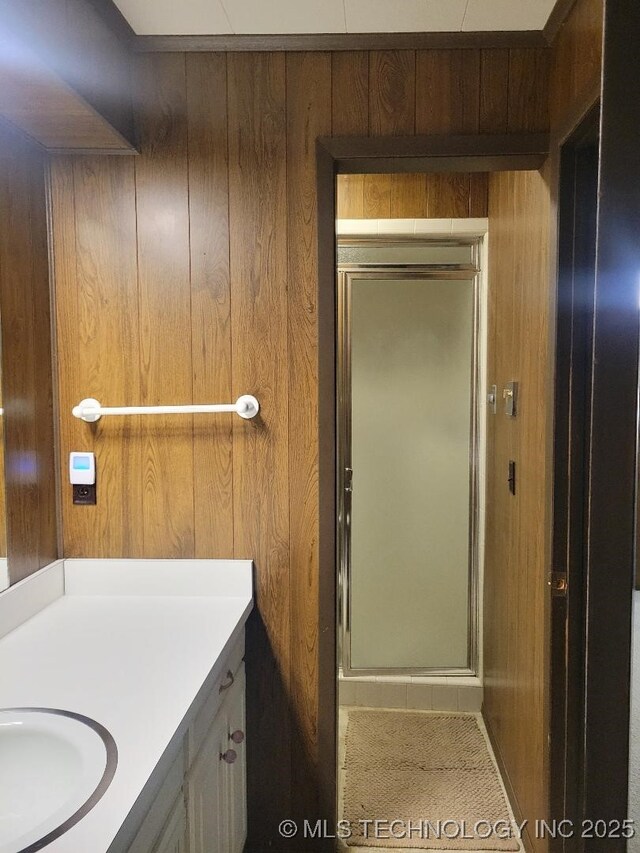 1296 Robin Hood Rd, Eufaula, OK 74432 - bathroom featuring vanity, wood walls, and a stall shower