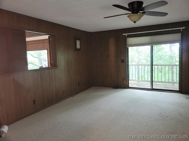 1296 Robin Hood Rd, Eufaula, OK 74432 - empty room featuring light colored carpet, wooden walls, and ceiling fan