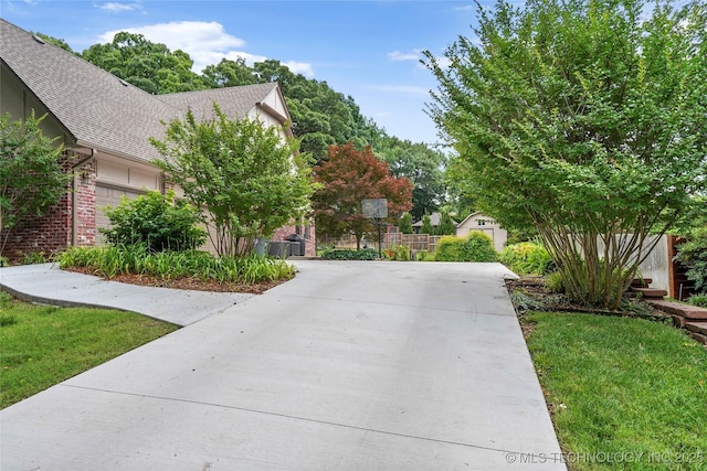 8609 S Joplin Ave, Tulsa, OK 74137 - view of front of house with a shingled roof, concrete driveway, and a front lawn