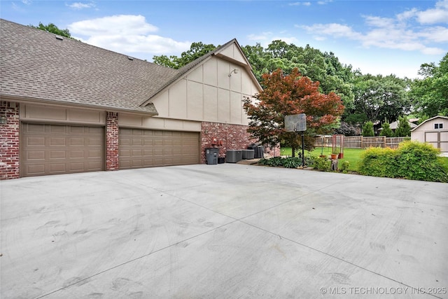 8609 S Joplin Ave, Tulsa, OK 74137 - view of side of home featuring brick siding, roof with shingles, driveway, and a garage