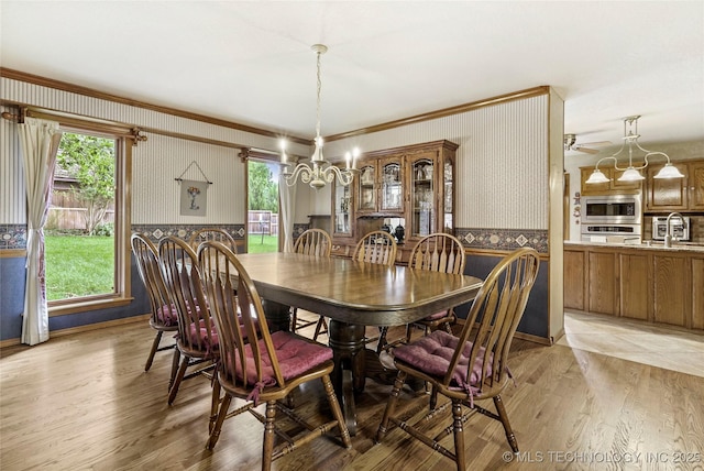 8609 S Joplin Ave, Tulsa, OK 74137 - dining space with wallpapered walls, wainscoting, a chandelier, ornamental molding, and light wood-style floors