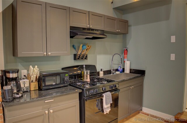 2328 S Delaware Ct, Tulsa, OK 74114 - kitchen with black appliances, under cabinet range hood, light wood-style flooring, and dark stone countertops
