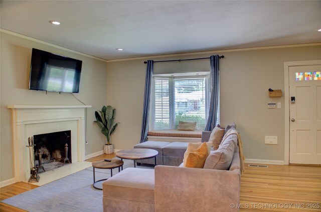 2328 S Delaware Ct, Tulsa, OK 74114 - living room featuring light wood-style floors, ornamental molding, a fireplace with flush hearth, and recessed lighting