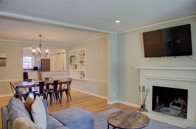 2328 S Delaware Ct, Tulsa, OK 74114 - living room featuring a chandelier, light wood-style floors, crown molding, a fireplace with flush hearth, and recessed lighting