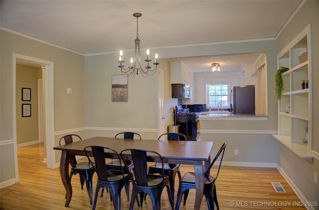 2328 S Delaware Ct, Tulsa, OK 74114 - dining area featuring a chandelier, light wood-style floors, and crown molding