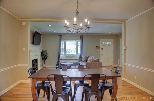 2328 S Delaware Ct, Tulsa, OK 74114 - dining room with light wood finished floors, a chandelier, a fireplace, recessed lighting, and crown molding