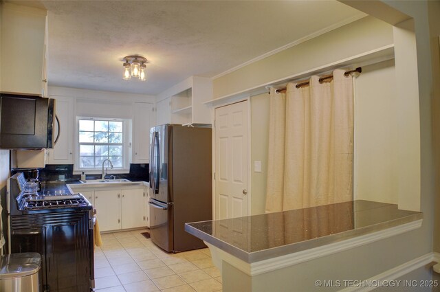 2328 S Delaware Ct, Tulsa, OK 74114 - kitchen with freestanding refrigerator, black microwave, white cabinets, light tile patterned floors, and open shelves