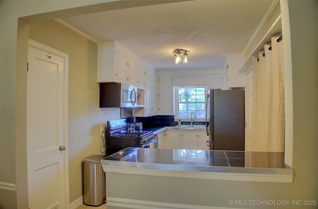 2328 S Delaware Ct, Tulsa, OK 74114 - kitchen with appliances with stainless steel finishes, white cabinets, and a peninsula