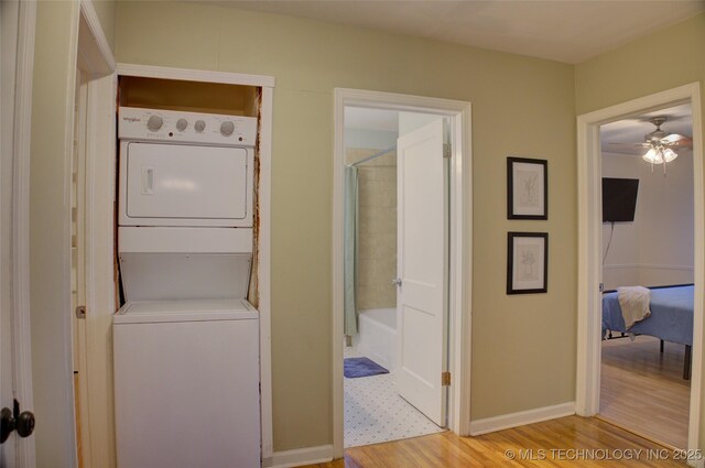 2328 S Delaware Ct, Tulsa, OK 74114 - laundry area featuring stacked washing machine and dryer, light wood-type flooring, and a ceiling fan