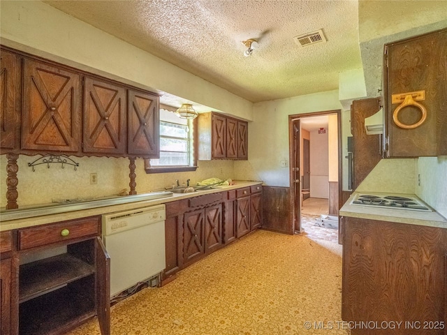 1015 Diehl Ln, Hartshorne, OK 74547 - kitchen with white appliances, a textured ceiling, brown cabinetry, light countertops, and range hood