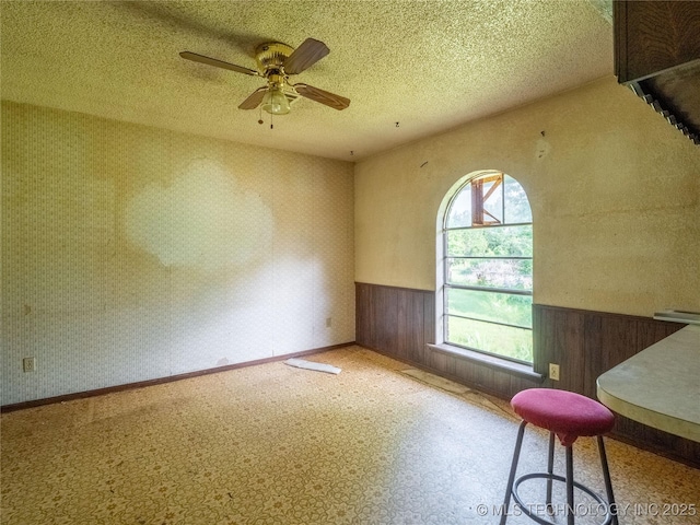1015 Diehl Ln, Hartshorne, OK 74547 - unfurnished room featuring wainscoting, ceiling fan, and a textured ceiling