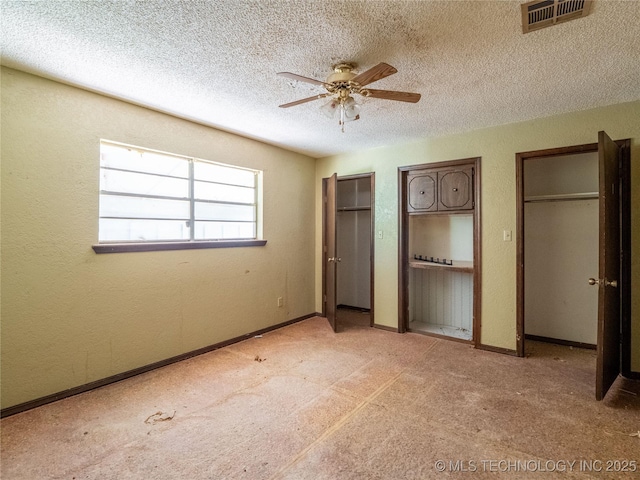 1015 Diehl Ln, Hartshorne, OK 74547 - unfurnished bedroom featuring multiple closets, a textured ceiling, a ceiling fan, and light colored carpet