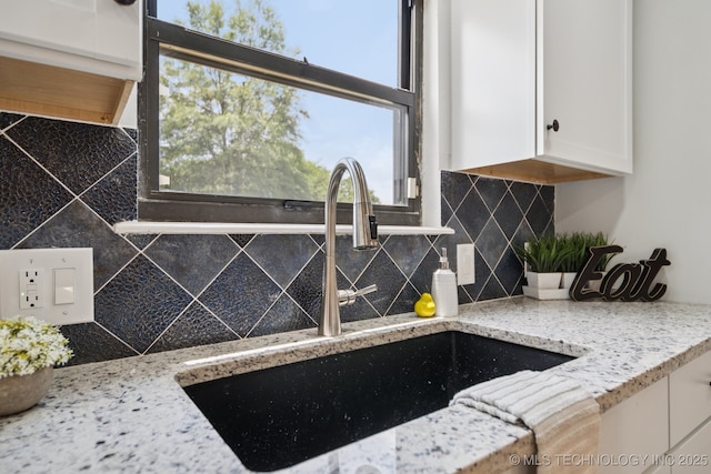 7927 S 86th E Ave, Tulsa, OK 74133 - kitchen view of white cabinets, decorative backsplash, and light stone countertops