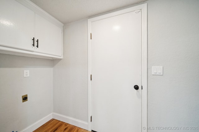 7927 S 86th E Ave, Tulsa, OK 74133 - washroom with electric dryer hookup, cabinet space, and light wood-style flooring
