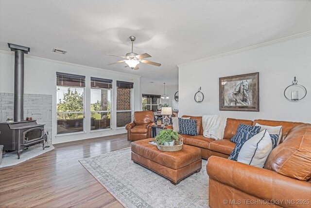 330 Loma Vista Ln, Skiatook, OK 74070 - living room featuring ornamental molding, a ceiling fan, a wood stove, and wood finished floors