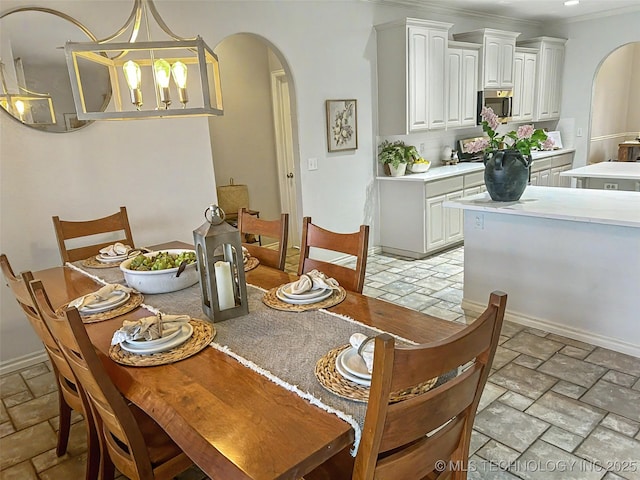 330 Loma Vista Ln, Skiatook, OK 74070 - dining space featuring arched walkways, stone tile floors, and a chandelier