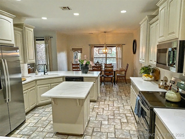 330 Loma Vista Ln, Skiatook, OK 74070 - kitchen with stainless steel appliances, a peninsula, stone tile floors, plenty of natural light, and recessed lighting