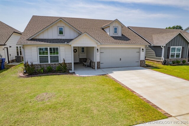 1813 E Van Buren Pl, Broken Arrow, OK 74011 - view of front facade featuring an attached garage, board and batten siding, a shingled roof, driveway, and a front lawn