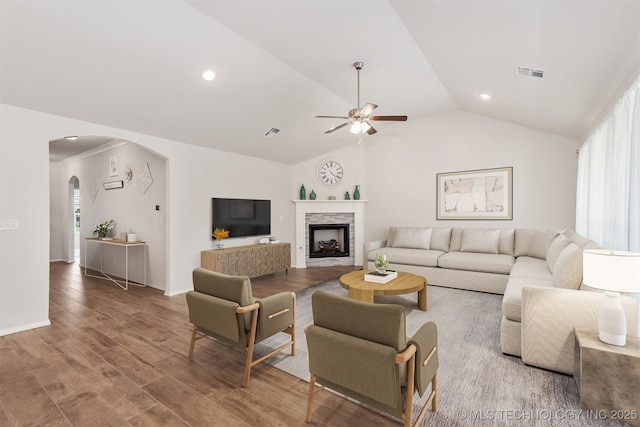 1813 E Van Buren Pl, Broken Arrow, OK 74011 - living room with vaulted ceiling, ceiling fan, arched walkways, a stone fireplace, and wood finished floors