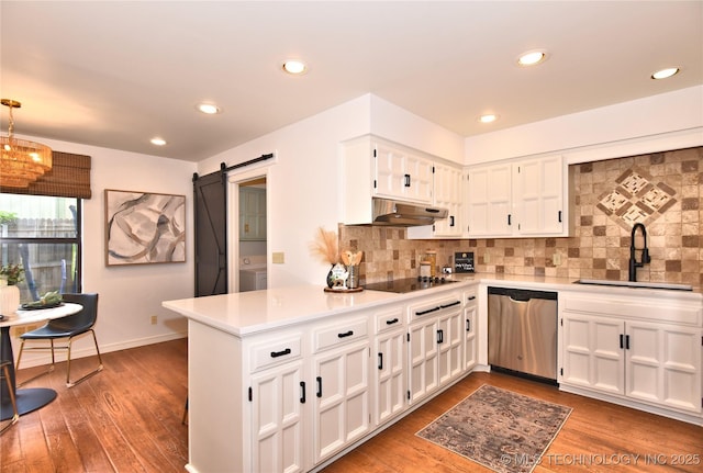 8504 S Winston Ave, Tulsa, OK 74137 - kitchen with stainless steel dishwasher, under cabinet range hood, a barn door, black electric cooktop, and white cabinetry