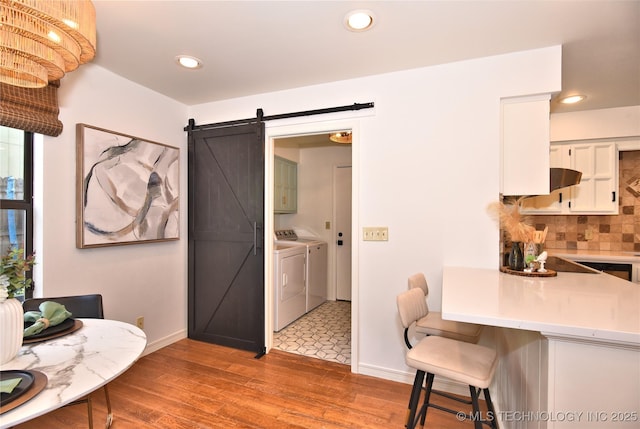8504 S Winston Ave, Tulsa, OK 74137 - dining space featuring separate washer and dryer, a barn door, light wood-style floors, and recessed lighting
