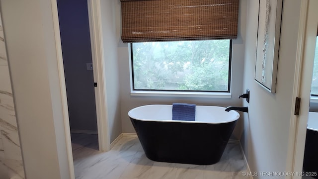 8504 S Winston Ave, Tulsa, OK 74137 - full bathroom featuring marble look tiles and a freestanding tub