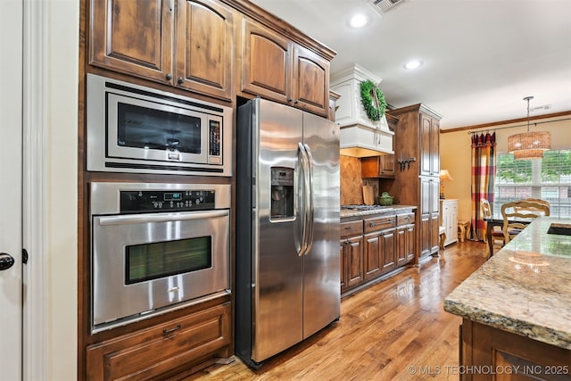 4733 S 167th E Pl, Tulsa, OK 74134 - kitchen with stainless steel appliances, light wood-style floors, light stone countertops, decorative light fixtures, and recessed lighting