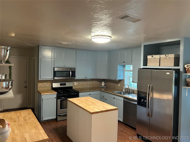 119 E Quesenbury, Sallisaw, OK 74955 - kitchen featuring appliances with stainless steel finishes, butcher block counters, dark wood-type flooring, and a center island