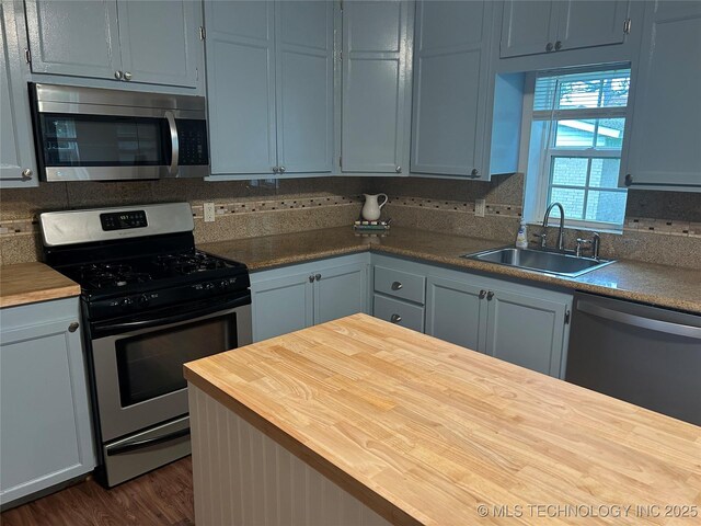 119 E Quesenbury, Sallisaw, OK 74955 - kitchen featuring stainless steel appliances, wooden counters, dark wood-style floors, and backsplash
