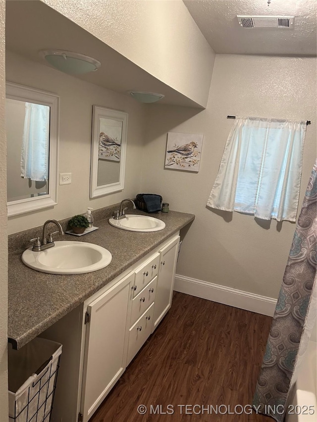 119 E Quesenbury, Sallisaw, OK 74955 - bathroom featuring wood finished floors and double vanity