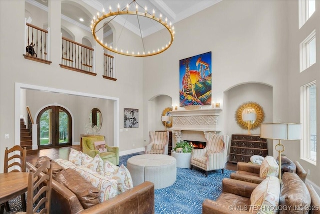 20565 E Clear Brook Rd, Owasso, OK 74055 - living room with a towering ceiling, a warm lit fireplace, ornamental molding, french doors, and arched walkways
