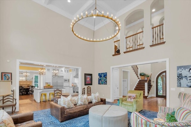 20565 E Clear Brook Rd, Owasso, OK 74055 - living area with a chandelier, wood finished floors, a high ceiling, stairs, and crown molding