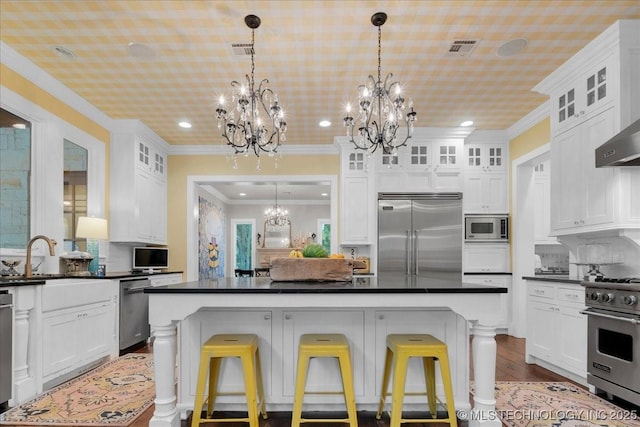 20565 E Clear Brook Rd, Owasso, OK 74055 - kitchen featuring built in appliances, a chandelier, dark countertops, recessed lighting, and white cabinetry