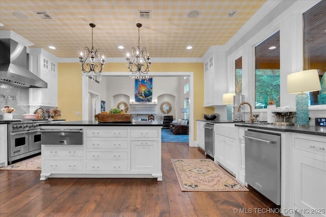 20565 E Clear Brook Rd, Owasso, OK 74055 - kitchen with stainless steel appliances, dark countertops, wall chimney exhaust hood, a warming drawer, and crown molding