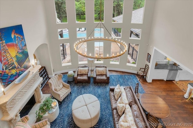 20565 E Clear Brook Rd, Owasso, OK 74055 - living area featuring a towering ceiling, wood finished floors, healthy amount of natural light, and a chandelier