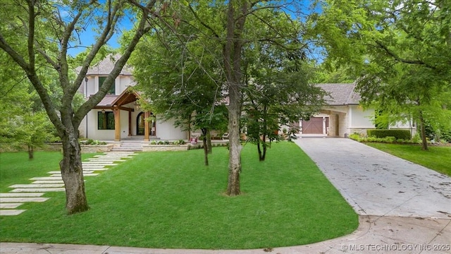 20565 E Clear Brook Rd, Owasso, OK 74055 - view of property hidden behind natural elements featuring stucco siding, a front yard, and driveway